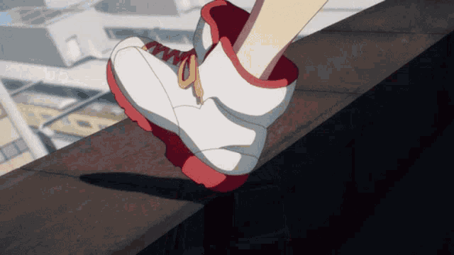 a close up of a person 's feet wearing white and red shoes