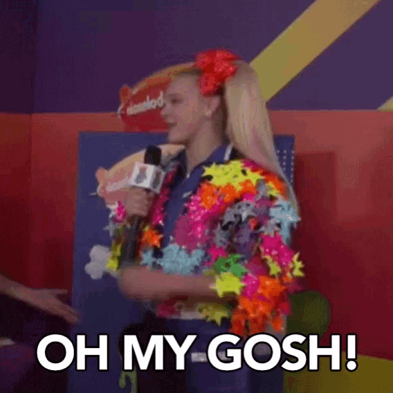 a girl in a colorful outfit is holding a microphone and says oh my gosh !