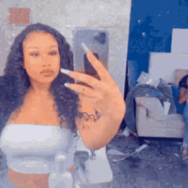 a woman is taking a selfie with her phone in a mirror .