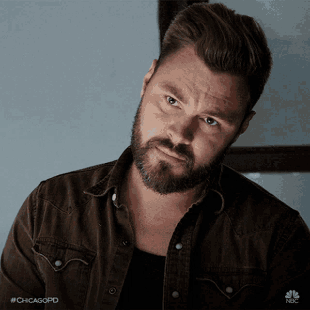 a man with a beard is wearing a brown shirt with the hashtag #chicagopd on the bottom