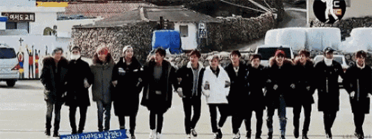 a group of people are standing next to each other in front of a building .