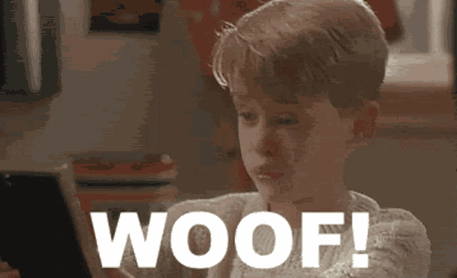 a young boy is crying while looking at a tablet and the word woof is on the screen .