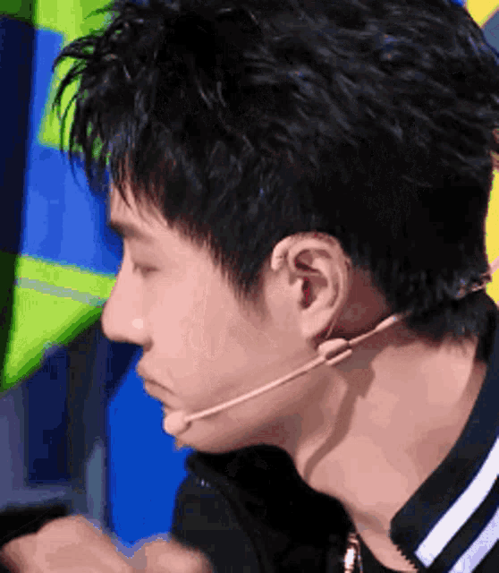 a close up of a man wearing a microphone around his neck .