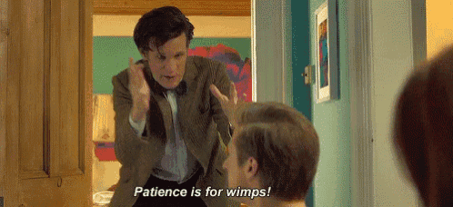 a man in a suit is standing next to another man in a hallway and saying `` patience is for wimps '' .