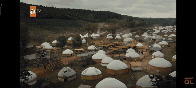an aerial view of a village with yurts and a tv logo