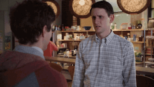 a man in a plaid shirt stands next to another man