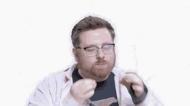 a man with a beard wearing glasses and a pink jacket is making a funny face .