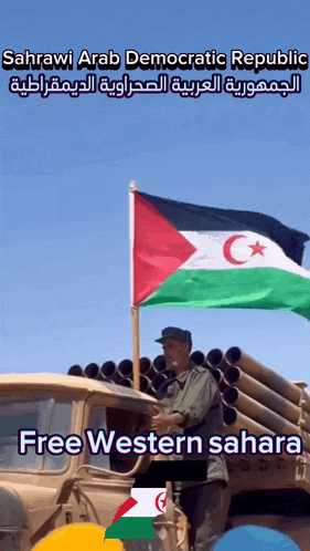 a man holding a flag in front of a truck that says free western sahara