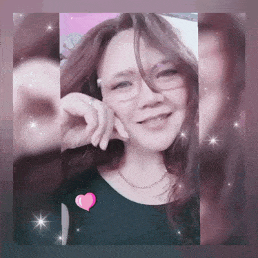 a woman wearing glasses and a black top has a pink heart on her chest