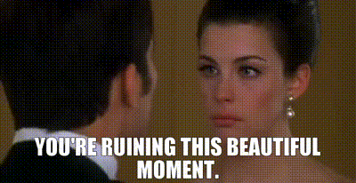 a man and a woman are looking at each other with the words `` you 're ruining this beautiful moment '' written below them .