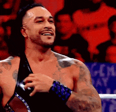 a man with a lot of tattoos is smiling in a ring