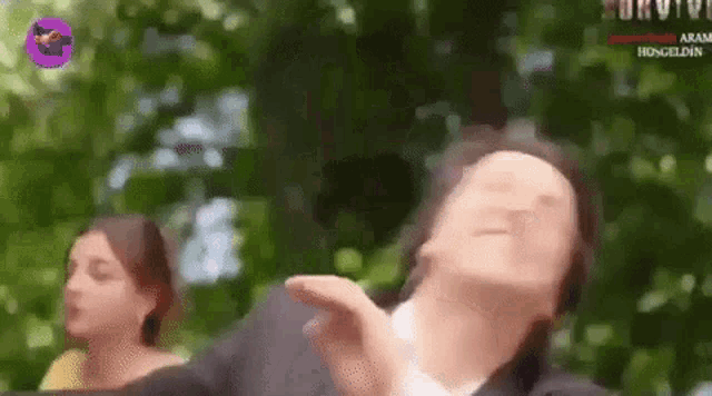 a man in a suit is making a funny face while standing next to a woman in a yellow dress .