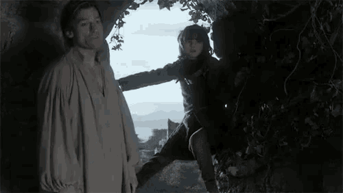 a man and a boy are standing next to each other in a dark room .