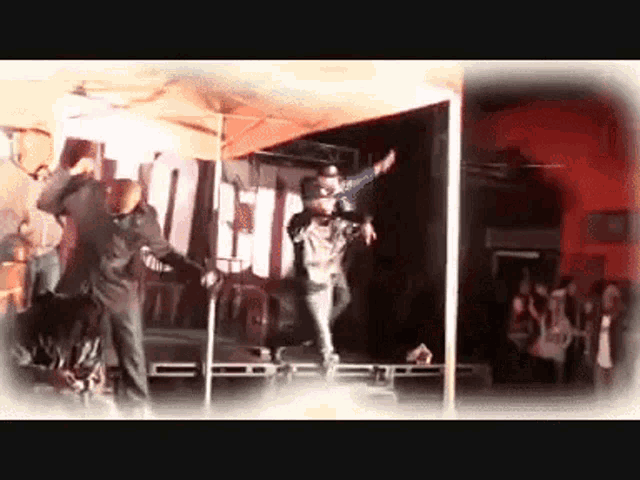 a group of people are dancing on a stage in front of a sign that says ' liberty '