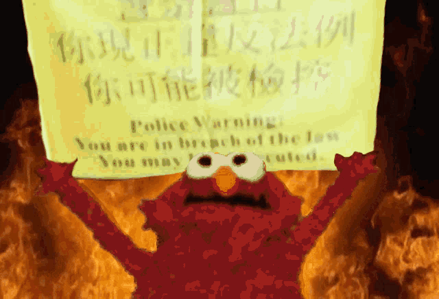elmo is holding a yellow sign that says police warning you are in breach of the law you may be executed