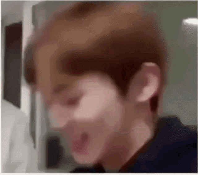 a blurry picture of a young man with his mouth open .