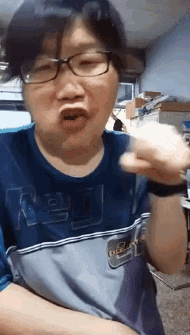 a man wearing glasses and a blue shirt that says russell on it