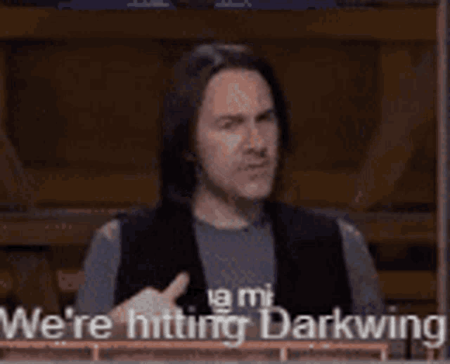a man with long hair is holding his hands to his chest and says `` we 're hitting darkwing '' .