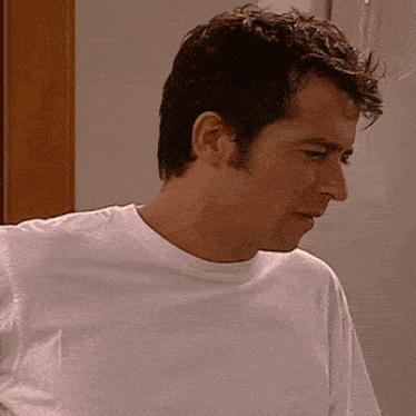 a man wearing a white t-shirt with the letter e on the front