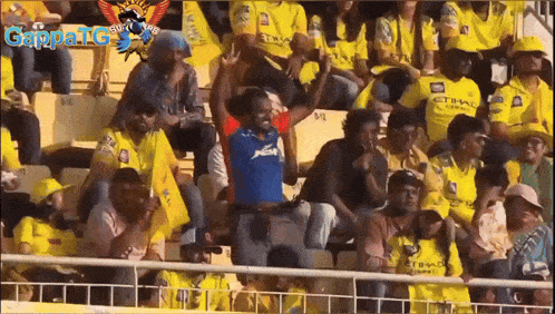 a group of people sitting in a stadium with gappatg written on the bottom right