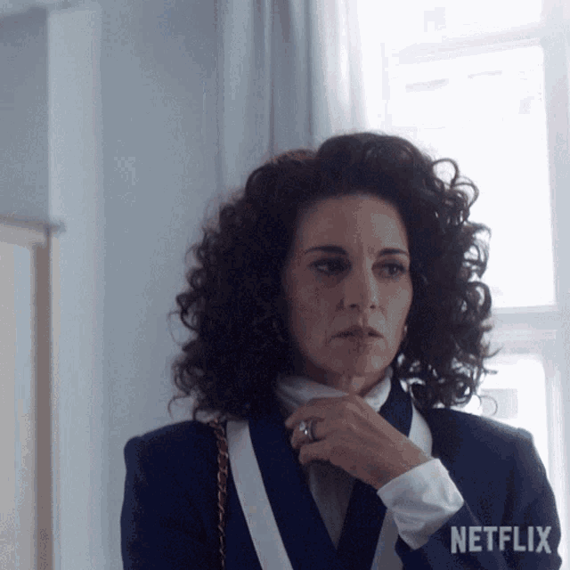 a woman with curly hair is wearing a netflix logo on her jacket