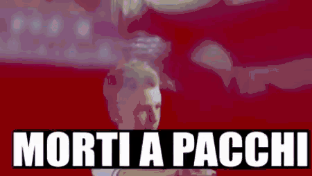 a man is standing in front of a red background with the words morti a pacchi written on it .