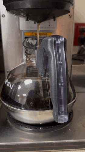 a bunn coffee maker is being used to make a cup of coffee