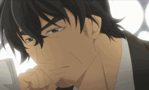 a man with black hair and a beard looks down at something
