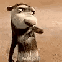 a close up of a cartoon monkey standing on a sandy surface .