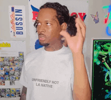 a man wearing a white shirt that says `` unfriendly hot la native ''