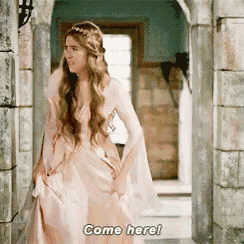 a woman in a pink dress is standing in a doorway and saying come here .