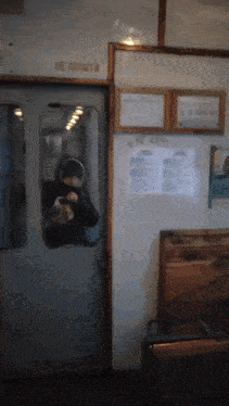 a person standing in a doorway with a sign on the wall that says " не ходить " on it