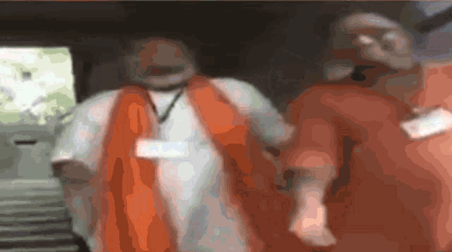 a blurry picture of two people wearing orange shirts