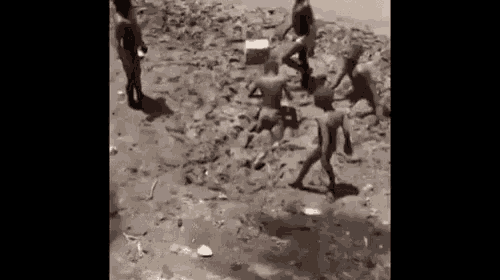 a group of children are playing in the mud .