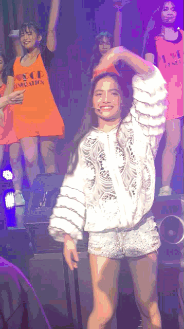 a girl wearing an orange shirt that says ice education is dancing on stage