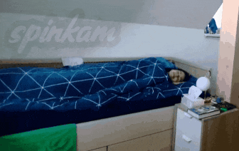 a person laying on a bed with the word spinkam written on the wall behind them
