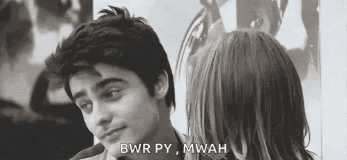 a man and a woman are looking at each other in a black and white photo and the man is talking to the woman .