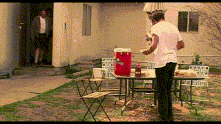 a man standing in front of a table with a red cooler