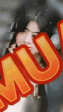 a close up of a woman behind a sign that says mu