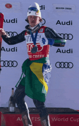 a man holding skis and wearing a shirt that says audi