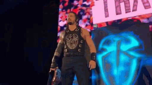 a wrestler is standing in front of a sign that says ' tna '
