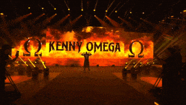 a stage with a large screen that says kenny omega on it