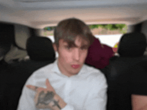 a man in a white shirt with a tattoo on his wrist