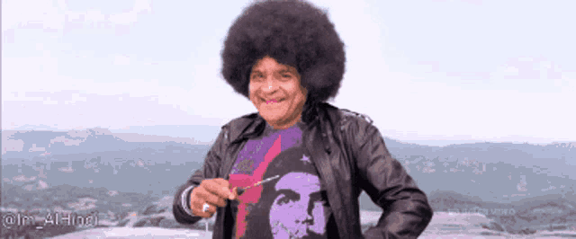 a man with a large afro is wearing a che guevara t-shirt