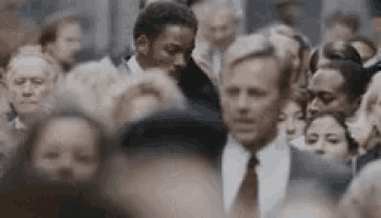a man in a suit is standing in a crowd of people .