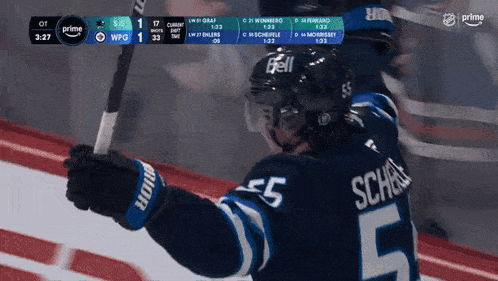 a hockey player with the number 5 on his jersey is holding a hockey stick