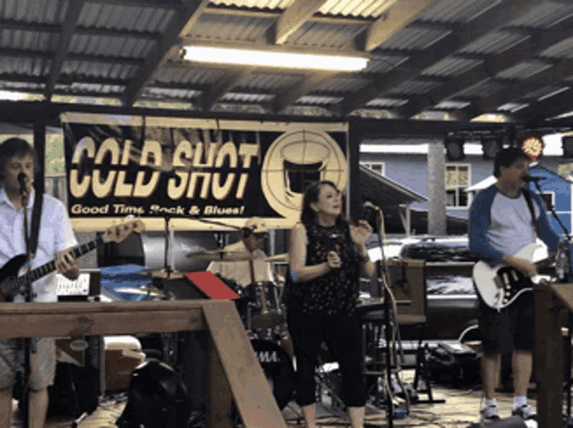 a band is playing under a roof with a sign that says cold cuat