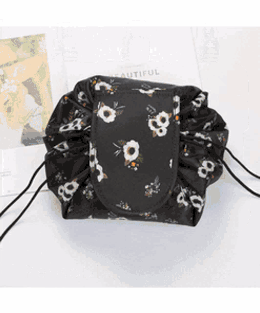 a black bag with white flowers on it is sitting on a table