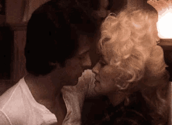 a man and a woman are kissing each other in a dark room .