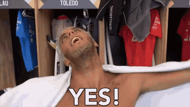 a shirtless man is wrapped in a towel in a locker room that says yes